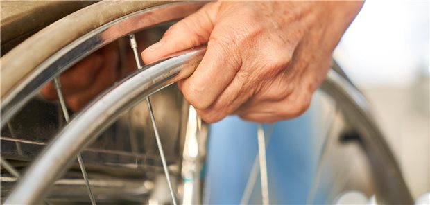 Sozialgericht Marburg: Fit und selbstbestimmt nur mit Aktivrollstuhl Hand eines Patienten am Reifen eines Rollstuhls.