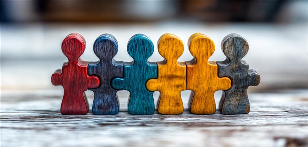 Inklusiver Arbeitsplatz? Warum Praxen von Vielfalt im Team besonders profitieren Eine Reihe von Holzfiguren steht nebeneinander.