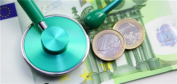 Privatanteil an den Einnahmen geht leicht zurück Geldschein, teilweise bedeckt von Stethoskop