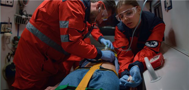 Wiederbelebung: Wie hängt die Adrenalin-Gabe mit dem Outcome zusammen? Zwei Rettungssanitäter leisten medizinische Hilfe für einen Patienten im Krankenwagen.
