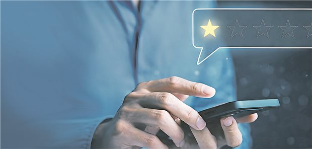 Bewertungsportale: Arzt muss Hinweis auf Löschung hinnehmen Mann gibt am Smartphone eine schlechte Bewertung ab.