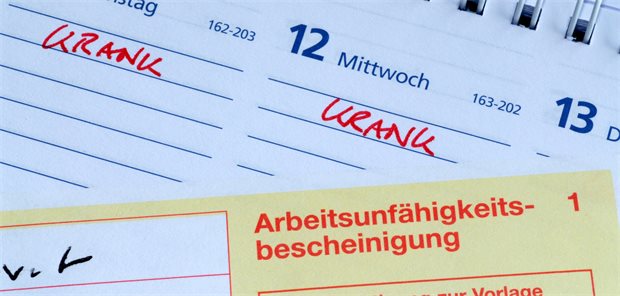 VdK-Umfrage: Attestpflicht ab erstem Tag könnte Fehlzeiten verlängern Formular Arbeitsunfähigkeitsbescheinigung auf Tischkalender.