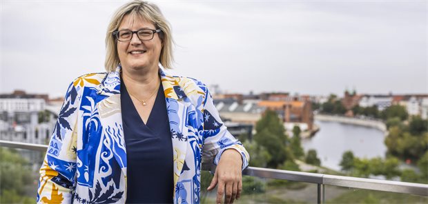 G-BA-Vorsitzende Sonja Optendrenk sieht sich als Streiterin der Selbstverwaltung Sonja Optendrenk steht an einem Geländer, im Hintergrund ist die Spree zu sehen.