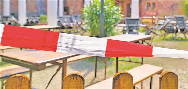 Drei Jahre Corona-Pandemie – die große Bilanz Striped barrier tape blocking off closed beer garden restaurant during Corona Virus lockdown