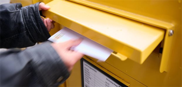 Rentenversicherung stellt Post-Versand von Rehaanträgen ein Mann wirft Brief in Briefkasten ein.