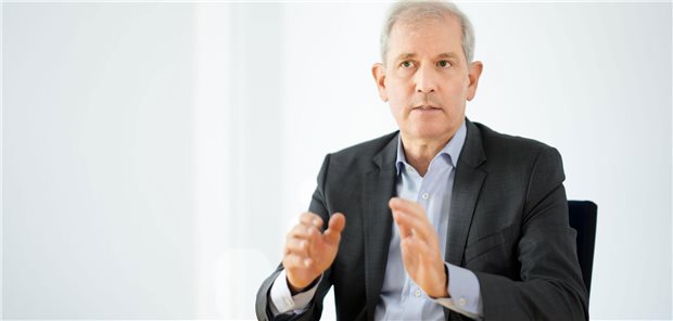 Uniklinika-Chef Jens Scholz: „Es fehlt ein langfristiges gesundheitspolitisches Zielbild“ Uniklinika-Chef Professor Jens Scholz sitzt auf einem Stuhl und hält seine Hände mit erklärender Gestik vor der Brust.