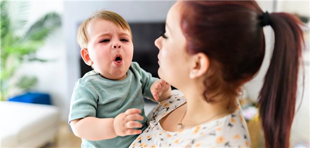 Akute Atemwegsinfekte: Vitamin D senkt Arztkontakte von Kindern nur geringfügig Eine Mutter hält ihr Kind auf dem Arm, es hustet.
