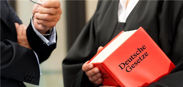 Tipps: So können Praxen die Risiken für einen GOÄ-Streit minimieren Ein Anwalt hält eine Gesetzessammlung in der Hand.