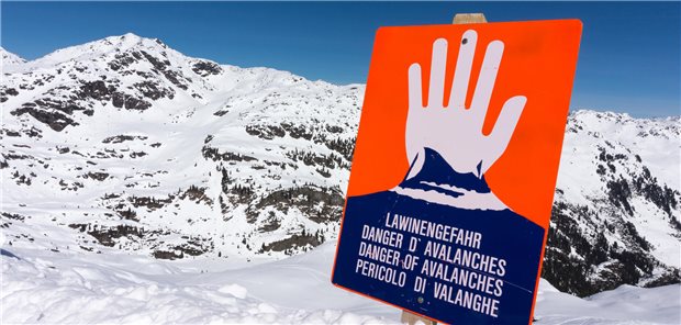 Schild &quot;Lawinengefahr&quot; steht im Schnee in den Bergen