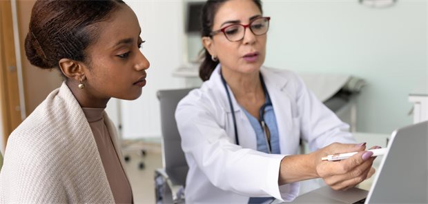 Wann Herkunft für die Diagnose wichtig ist – und wann sie zur Fehldiagnose führt Schwarze Patientin mit weißer Ärztin im Gespräch.