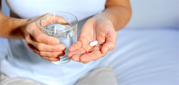 Generikaquoten: Ungleicher Patentablauf bringt Ärger bei DOAK-Verordnungen Patient hält Wasserglas in der einen Hand, in der anderen eine Tablette.