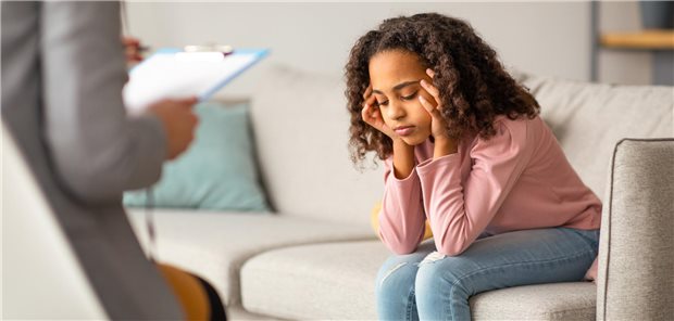 Vorzeitige Pubertät führt möglicherweise vermehrt zu psychischen Belastungen bei Jugendlichen Eine junge Patientin, die auf einer Couch in der Praxis ihres Psychologen sitzt und mit diesem über ihre Probleme spricht.