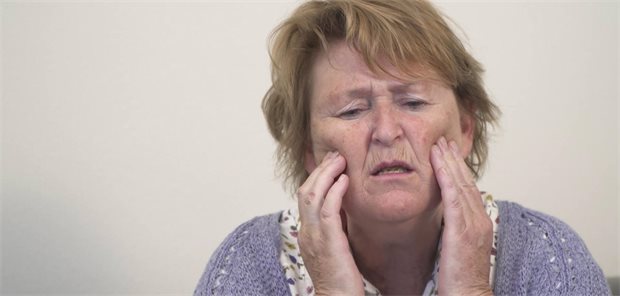 Schmerzen bei Demenz-Patienten: Welche Fallstricke lauern in der Diagnostik? Eine ältere Frau fässt sich mit den Händen ins Gesicht