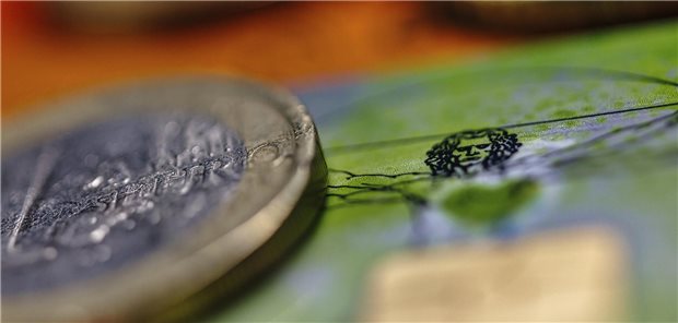 Bilanz für 2025: Gesetzliche Krankenkassen mit rund 3,5 Milliarden Euro Überschuss Das Foto zeigt eine 1-Euro-Münze, im Hintergrund ist das Motiv des vitruvianischen Menschen von Leonardo da Vinci auf einer GKV-Versichertenkarte zu sehen.