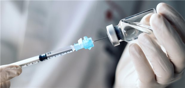 Review bestätigt: mRNA-Impfungen sind sicher und wirksam Jemand zieht mit einer Spritze Flüssigkeit aus einem Fläschchen.